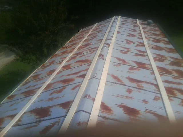 Rusted metal roof panels with new wood purlins before replacement — Storm Damage Roof Repair in Kenilworth by Roofing Brothers