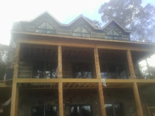 Dormers and porch framing on a large log home under construction — Roof Coating work by our crew in Kenilworth